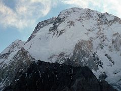30 Broad Peak North Summit, Central Summit And Main Summit Just After Sunrise From Concordia The three summits of Broad Peak are seen at sunrise from Concordia. The North Summit is on the far left, the Central Summit is in the middle with just a touch of sun, and on the far right is the Main Summit. The first ascent of Broad Peak was completed by Marcus Schmuck, Fritz Wintersteller, Kurt Diemberger, and Hermann Buhl on June 9, 1957. This extremely small expedition marked a major step forward in the development of Himalayan climbing. Diemberger: �[Buhl's] plan was that from base camp onwards there would only be climbers on the mountain; they would do everything, load-carrying, establishment of camps and, finally, the assault on the summit. And it was all to be done without the use of oxygen.� Diemberger reached the summit just as Marcus Schmuck and Fritz Wintersteller started their descent. As Diemberger was descending from the summit he met Buhl still ascending. �Slowly, with all that incredible strength of his will, he started to move, very slowly, upwards. ... Two men were standing on a peak, still breathing heavily from the ascent, their limbs weary - but they did not notice it; for the all-enveloping glory of the sun's low light had encompassed them too. Deeper and deeper grew the colours. ... No dream-picture, this. It was real enough, and it happened on the 26,404-foot summit of Broad Peak.� � Summits And Secrets by Kurt Diemberger.